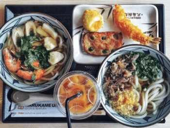 Discover the self-service udon noodle chain bustling with eager patrons.